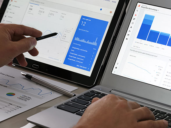 Businessperson reviewing analytics data on devices to measure the impact of content marketing services.